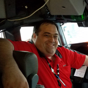 man wearing red shirt smiling in vechile
